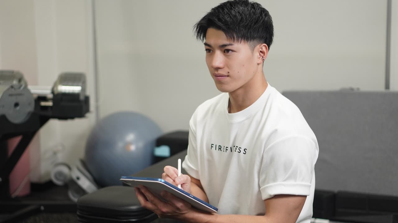 FIREFITNESSのトレーナーがタブレットでカウンセリングしている様子