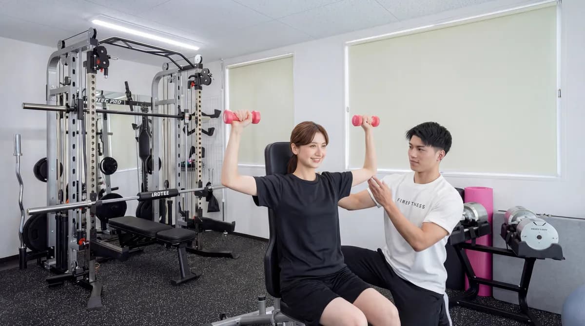 FIREFITNESS島田本町店で、葛本トレーナーが利用者のトレーニングを指導している様子